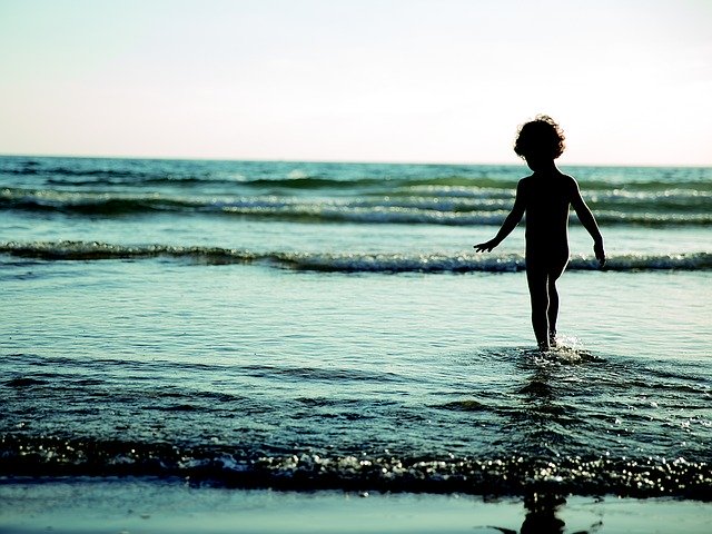 Silueta malého dieťaťa, ktoré kráča do mora.jpg